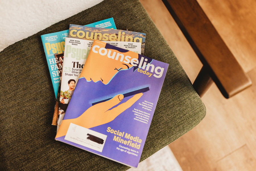 A fan of Counseling Today and Psychology Today issues resting on a green upholstered chair