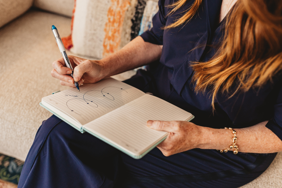 Lisa Giebelhaus writing a small diagram of circles in a lined notebook